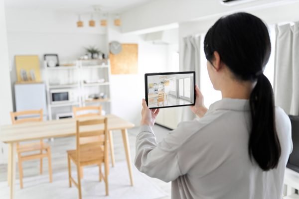 A woman using an AR app to simulate furniture placement A woman using an AR app to simulate furniture placement